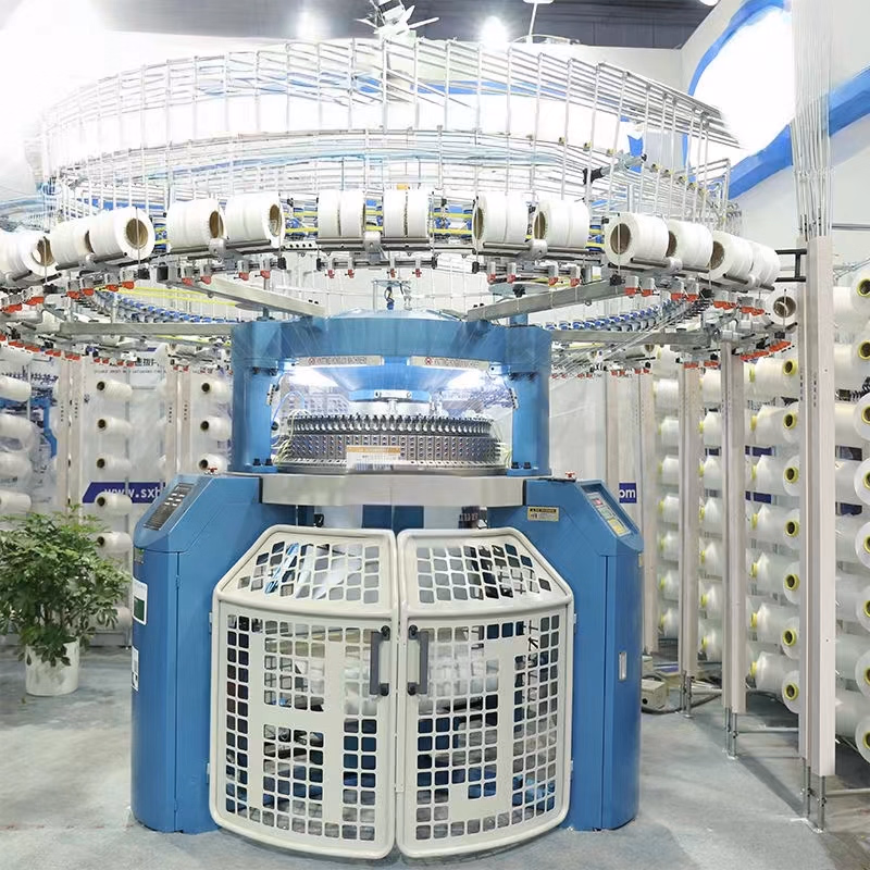 Large industrial circular knitting machine in operation, creating fabric